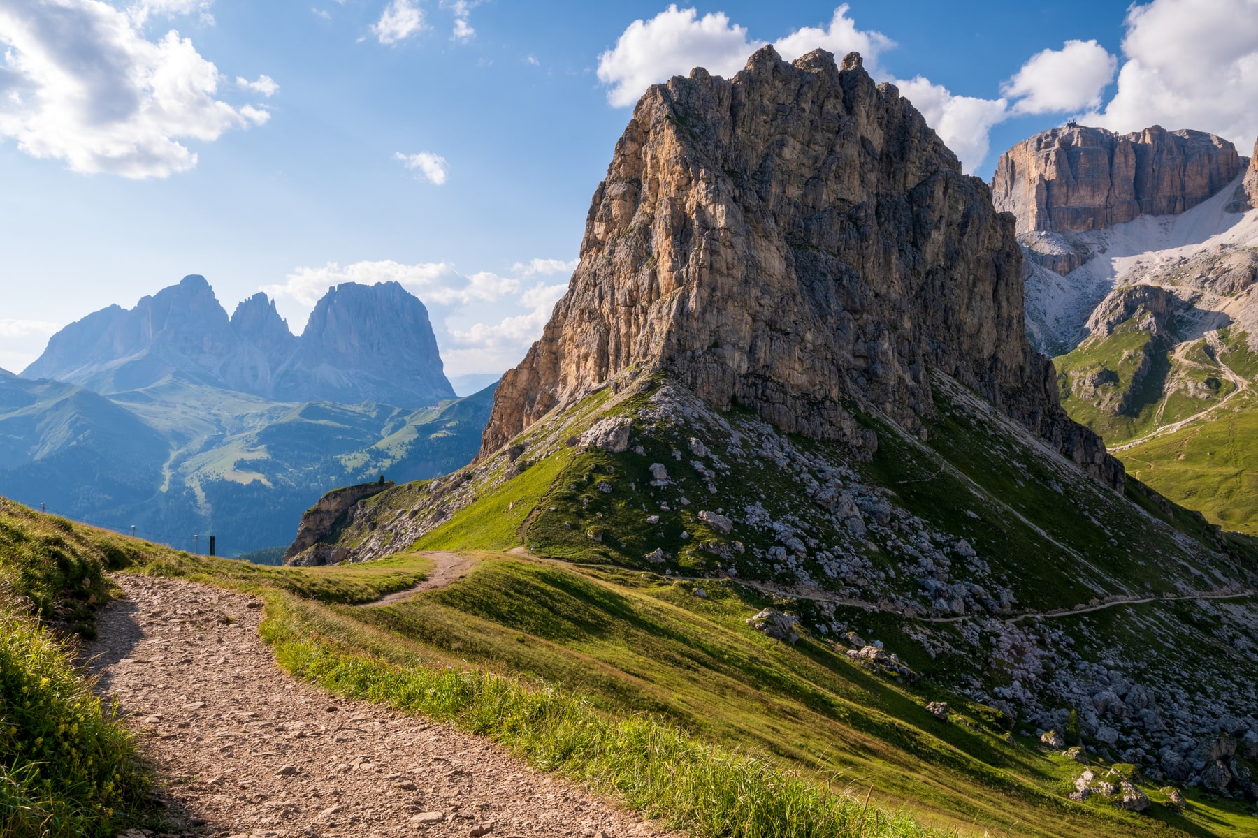 Sunlit peaks above a path in the Dolomites